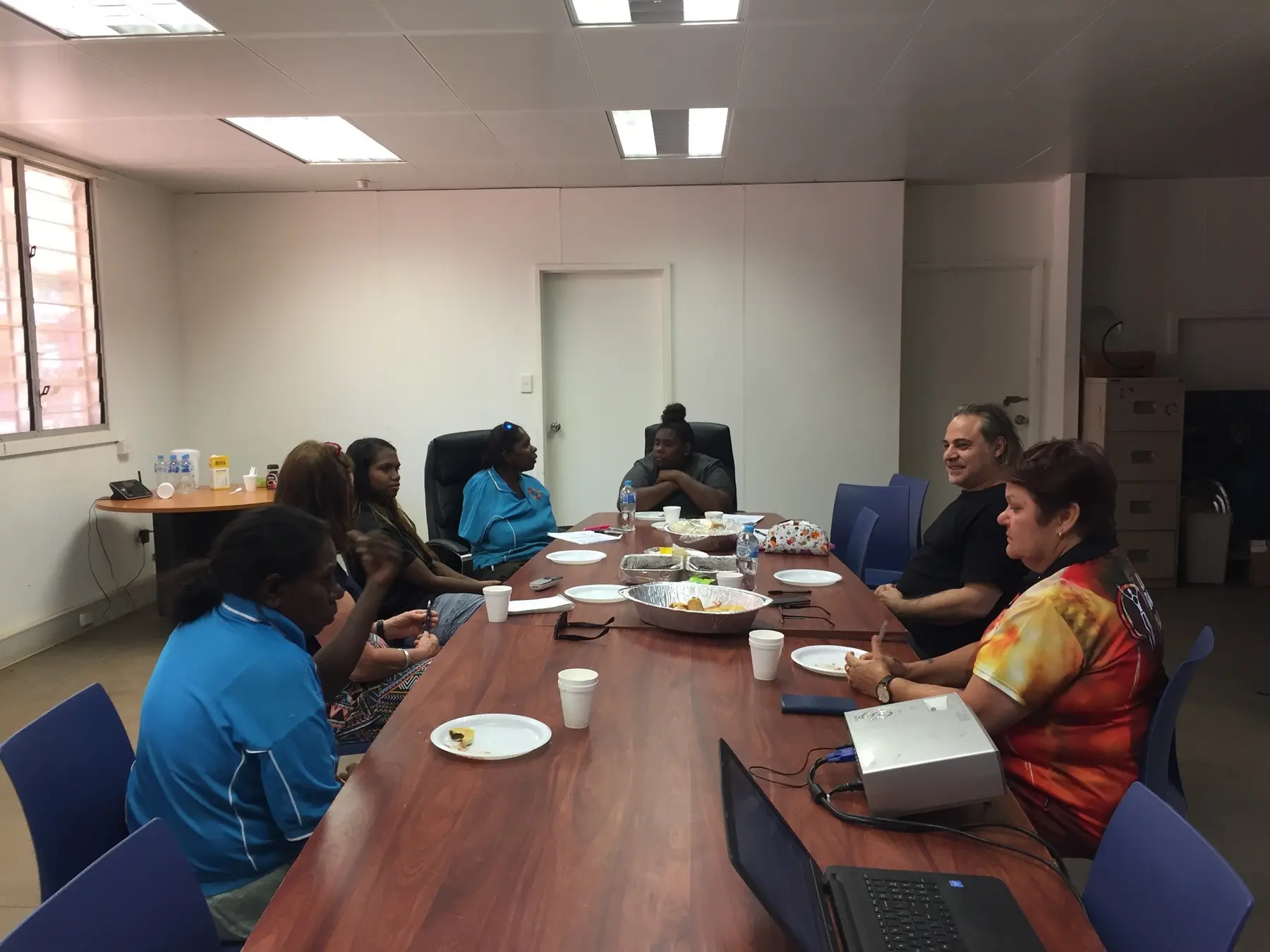 Community members gathered around a table for a collaborative project meeting