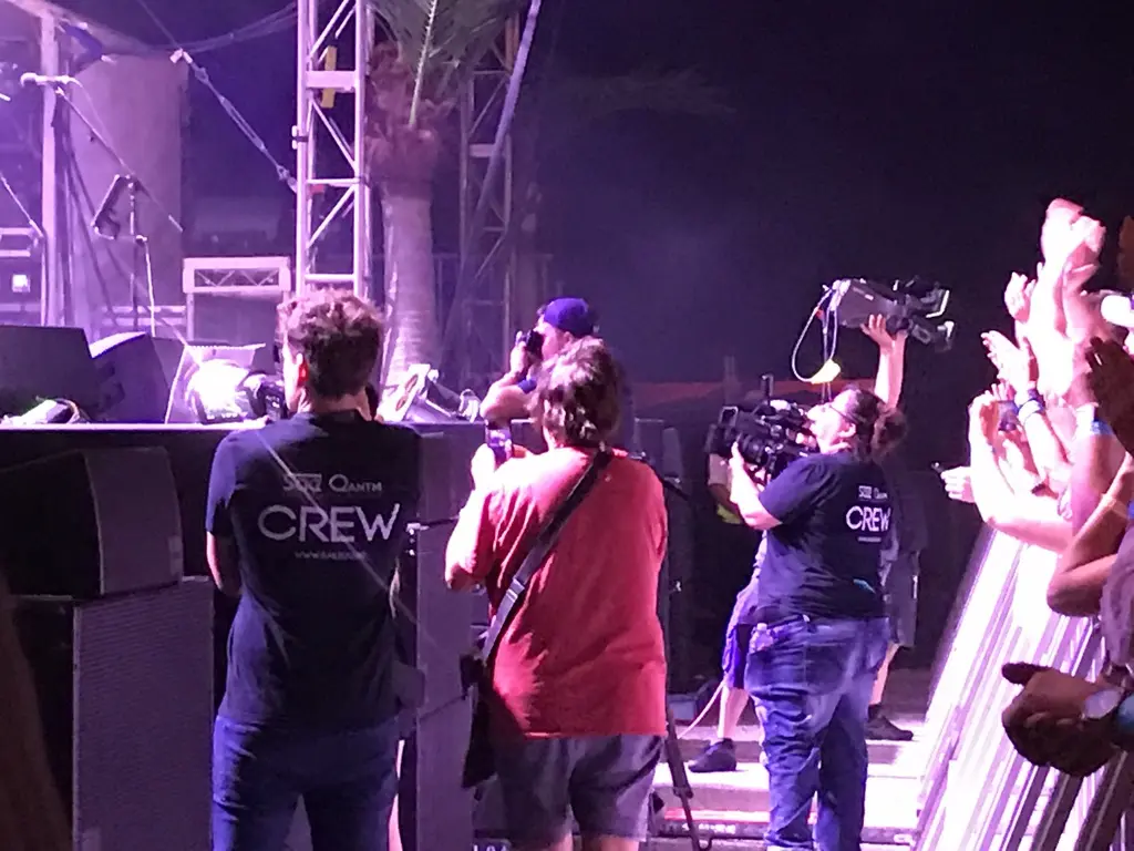 Camera and production crew working beside a live festival stage
