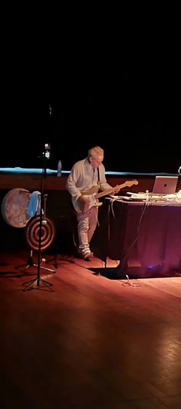 Sam Cutri playing electric guitar beside a gong during Sonic Aurora